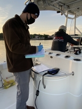IEC staff entering data on a boat
